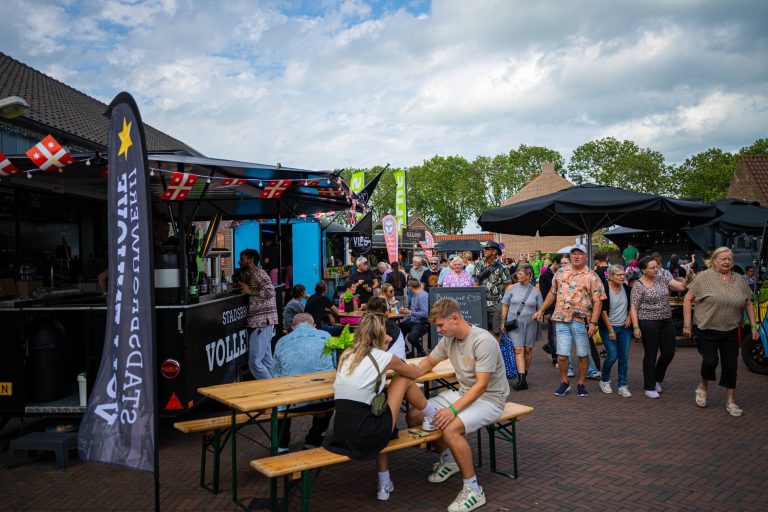 Bezoekers genieten van eten en drinken bij foodtrucks tijdens het Food & Flowers Festival in Vollenhove.
