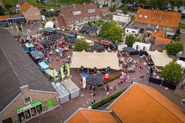 FoodFlowers3 Luchtfoto van het Food & Flowers Festival in Vollenhove met foodtrucks, overdekte zitplaatsen en bezoekers op het Marten Kingmaplein.